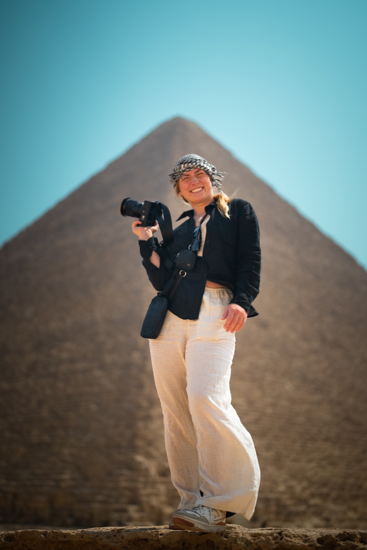 Syd Meyer with her camera in front of a pyramid in Egypt